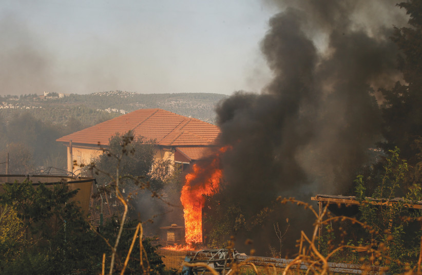  Flames approach houses in Givat Ye’arim, Monday. (credit: RONEN ZVULUN/REUTERS)