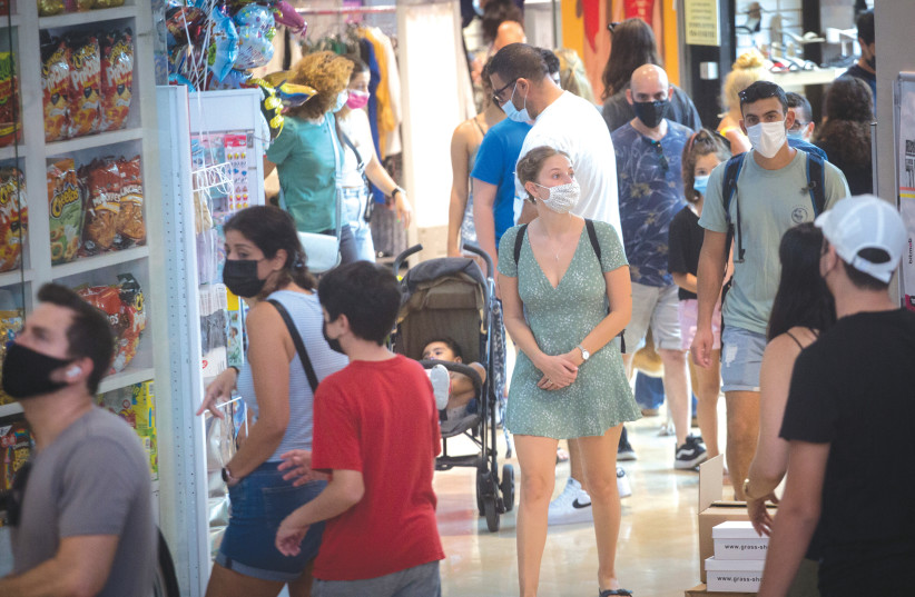  SHOPPERS WEAR protective face masks in Dizengoff Center in Tel Aviv, on Tuesday. (photo credit: MIRIAM ALSTER/FLASH90)