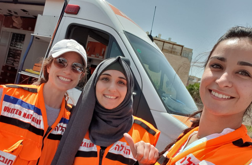 Three women EMT volunteers of United Hatzalah after finishing an ambulance shift in Jerusalem, one haredi, one religious Muslim, and one secular. (credit: UNITED HATZALAH‏)