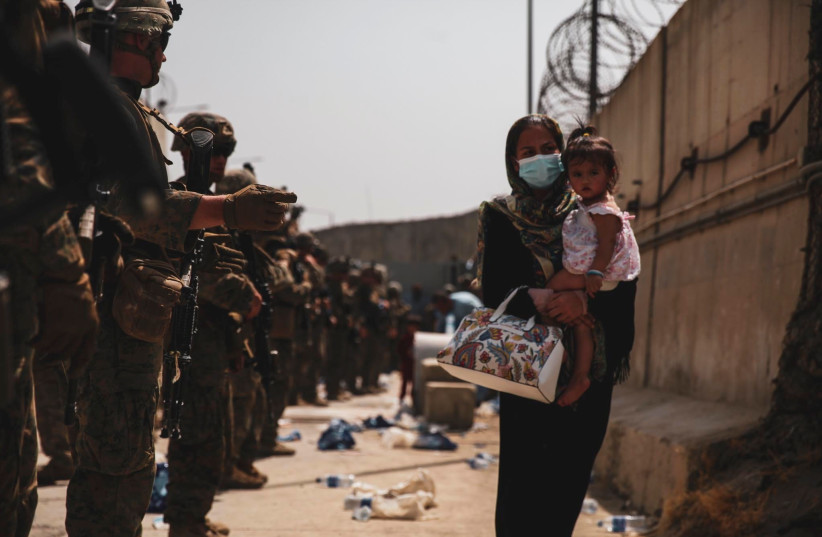  Marines with the 24th Expeditionary Unit (MEU) guide an evacuee during an evacuation at Hamid Karzai International Airport, Kabul, Afghanistan, in this photo taken on August 18, 2021 (credit: US NAVY/CENTRAL COMMAND PUBLIC AFFAIRS/SGT. ISAIAH COMPBELL/HANDOUT VIA REUTERS)
