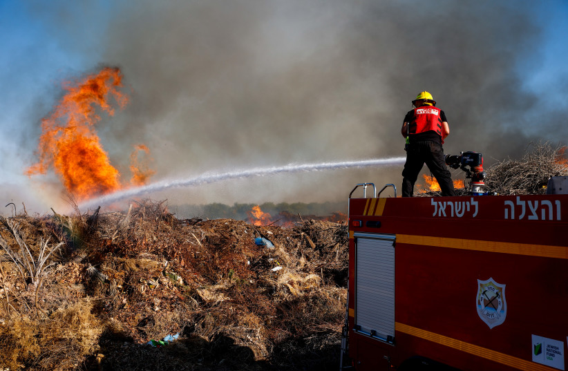  Firefighters try to extinguish a fire in the Simhoni forest caused by incendiary ballons sent by Palestinian terrorists into southern Israel. June 15, 2021. (credit: FLASH90)
