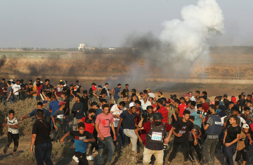  Palestinians hold anti-Israel protest at Israel-Gaza border fence, August 25, 2021 (credit: MOHAMMED SALEM/REUTERS)