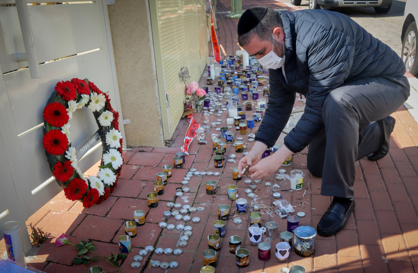 Shas parliament member Moshe Arbel lights a candle outside the home of Diana Raz, who was murdered by her husband at their home on Friday, in the West Bank settlement of Na’ale, on February 7, 2021.  (credit: AVI DISHI/FLASH90)