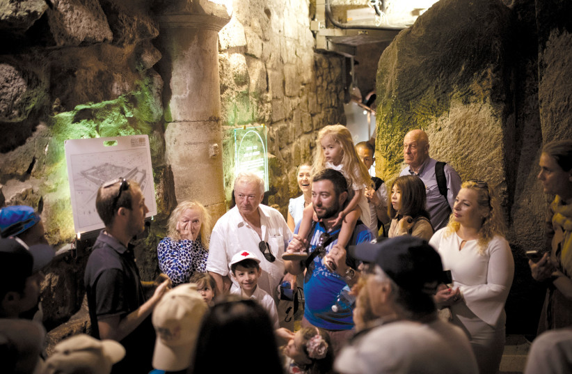  The way we were: A group of tourists listen to their guide inside the Western Wall Tunnels (photo credit: HADAS PARUSH/FLASH90)