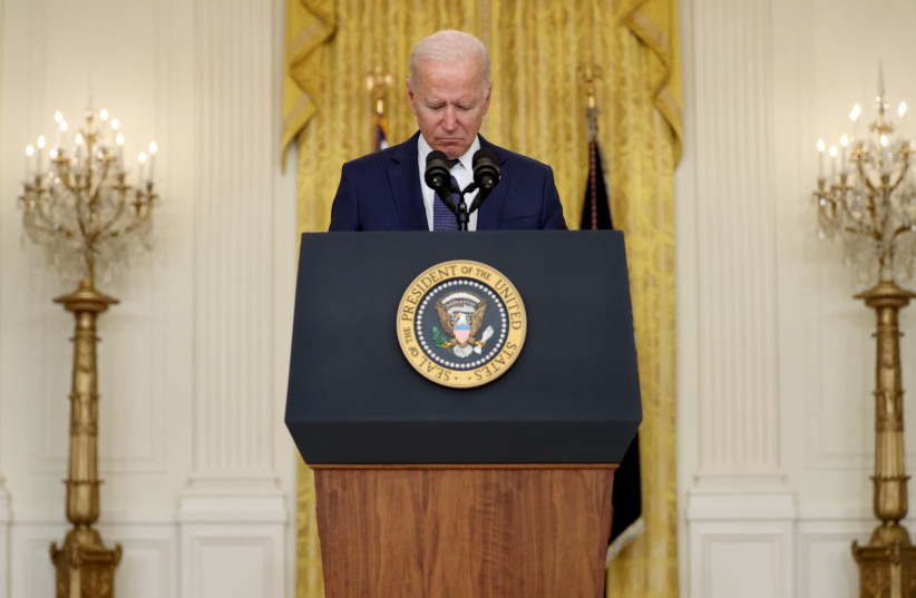  US President Joe Biden reacts during a moment of silence for the dead as he delivers remarks about Afghanistan, from the East Room of the White House in Washington, US August 26, 2021. (credit: REUTERS)