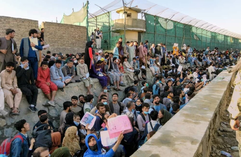 Des foules de gens attendent devant l'aéroport de Kaboul, en Afghanistan, le 25 août 2021 sur cette photo obtenue à partir des réseaux sociaux. (crédit photo : TWITTER/DAVID_MARTINON VIA REUTERS/FICHIER PHOTO)