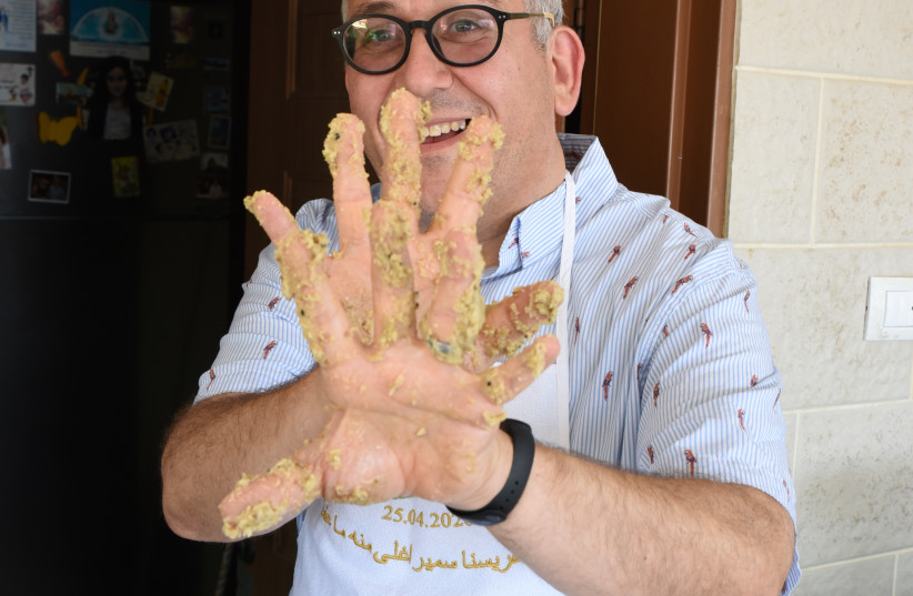  WRITER MARK GORDON shows off his doughy hands after preparing zalabia.  (credit: Courtesy)