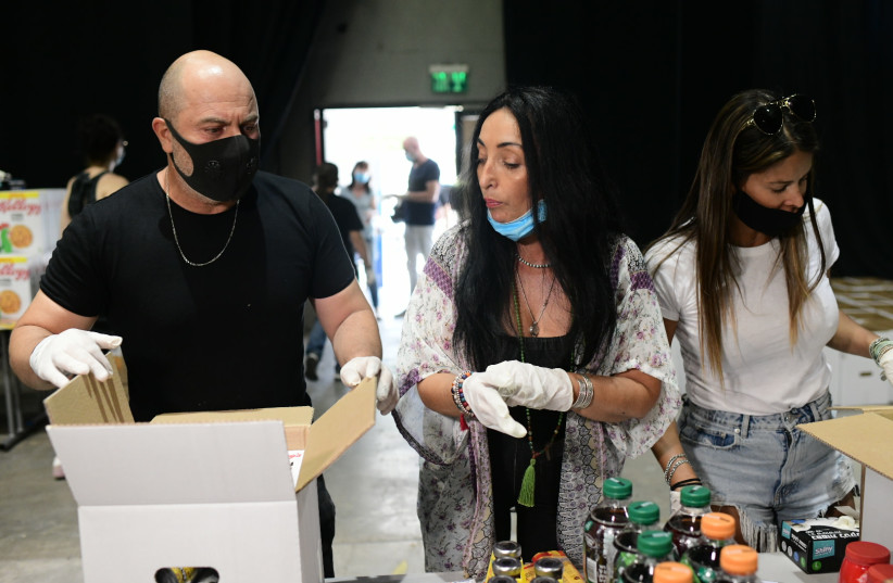  Lior Raz from the Israeli hit series ''Fauda'' seen with other Israeli artists and actors helping prepare food packages for those in need, following the economic difficulties and high unemployment due to restrictions set up to prevent the spread of the Coronavirus.  July 20, 2020. (credit: TOMER NEUBERG/FLASH90)