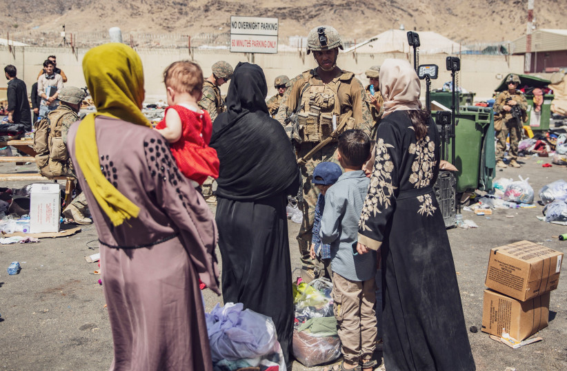  US Marines with the 24th Marine Expeditionary Unit (MEU) process evacuees as they go through the Evacuation Control Center (ECC) during an evacuation at Hamid Karzai International Airport, Kabul, Afghanistan, August 28, 2021. (photo credit: SGT. VICTOR MANCILLA/US MARINE CORPS/HANDOUT VIA REUTERS)