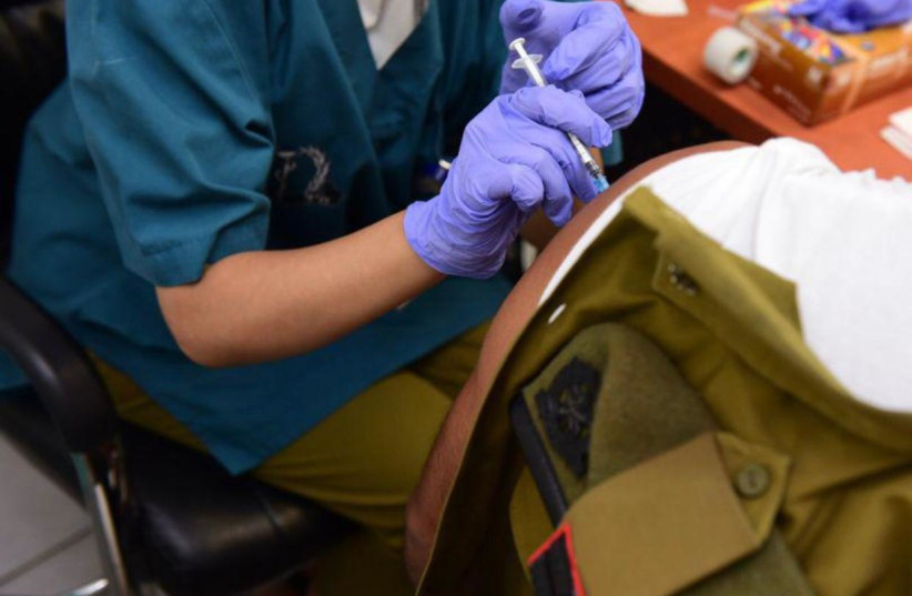   An IDF soldier is seen being given the third dose of the COVID-19 vaccine. (credit: IDF SPOKESPERSON'S UNIT)