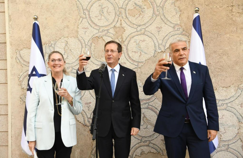  President Herzog raising a toast with the First Lady and Foreign Minister Yair Lapid (credit: AMOS BEN-GERSHOM/GPO)