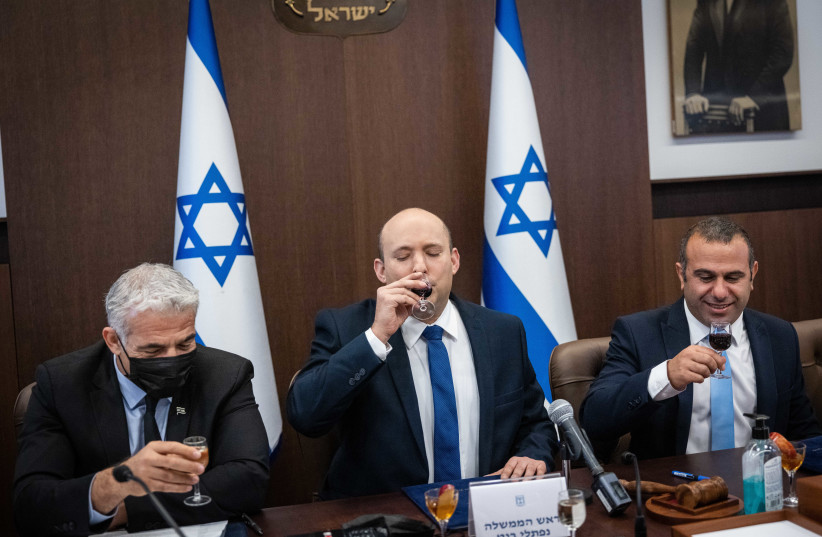  Prime Minister Naftali Bennett and Foreign Minister Yair Lapid toasting to the new year, September 5, 2021. (credit: YONATAN SINDEL/FLASH90)