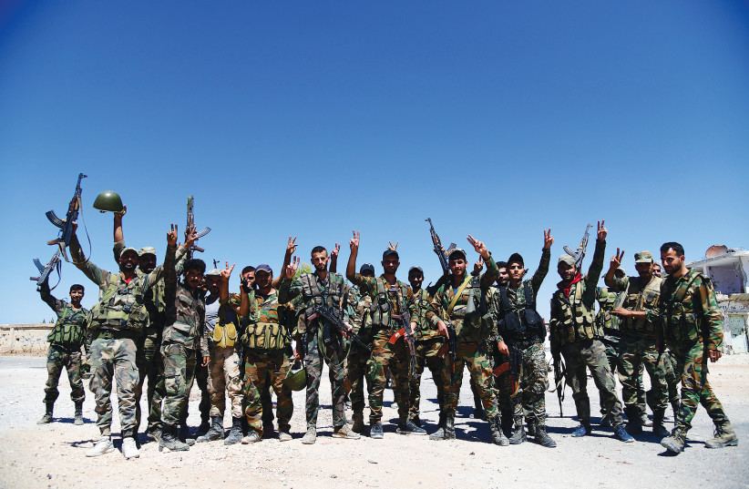  SYRIAN ARMY soldiers pose in Deraa al-Balad, this week. (credit: SANA/REUTERS)