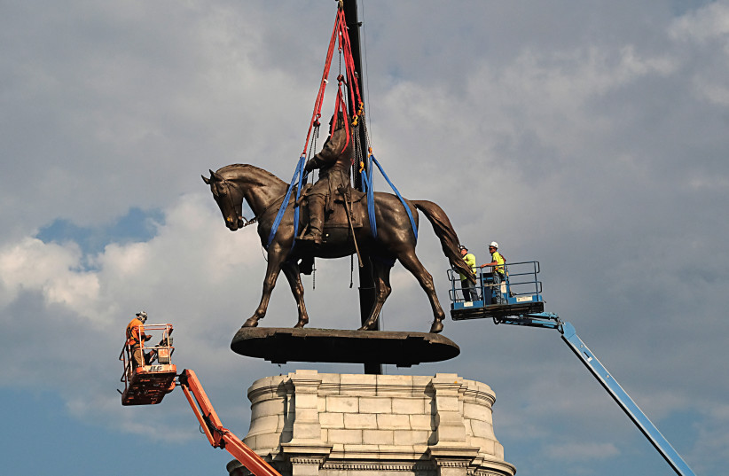  The statue of Confederate General Robert E. Lee is removed from its pedestal on Monument Avenue in Richmond, Virginia, U.S. September 8, 2021.  (credit: Bob Brown//Pool via REUTERS)