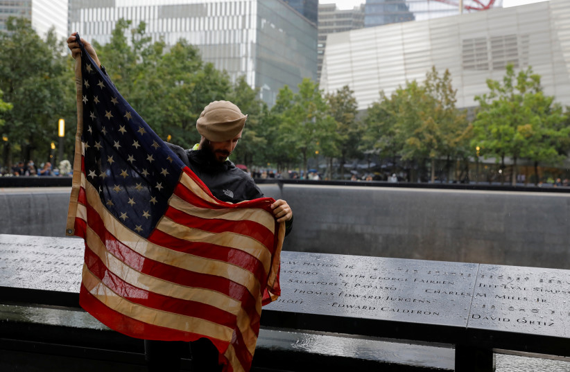  Jeremy Provancher, who served in Afghanistan with the Army 275 Ranger Regiment, carries a US flag that was used in Afghanistan, as he visits the 9/11 Memorial ahead of the 20th anniversary of the September 11 attacks in Manhattan, New York City, US, September 9, 2021.  (credit: REUTERS/ANDREW KELLY)