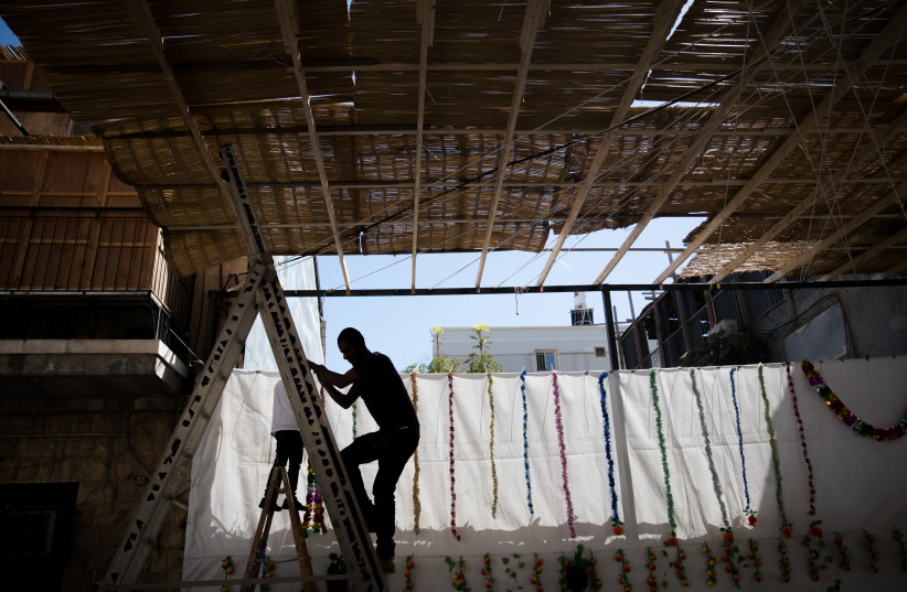  CONSTRUCTING THE sukkah.  (credit: YONATAN SINDEL/FLASH90)