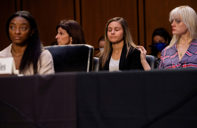 US gymnasts Jessica Howard and Kaylee Lorincz watch as US Olympic gymnast Simone Biles testifies during a Senate Judiciary hearing about the Inspector General's report on the FBI handling of the Larry Nassar investigation of sexual abuse of Olympic gymnasts. (credit: SAUL LOEB/POOL VIA REUTERS)