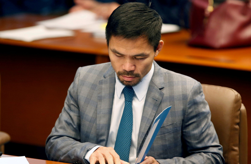  Philippine Senator and boxing champion Manny Pacquiao reads his briefing materials as he prepares for the Senate session in Pasay city, Metro Manila, Philippines September 20, 2016. (credit: REUTERS/ERIK DE CASTRO)