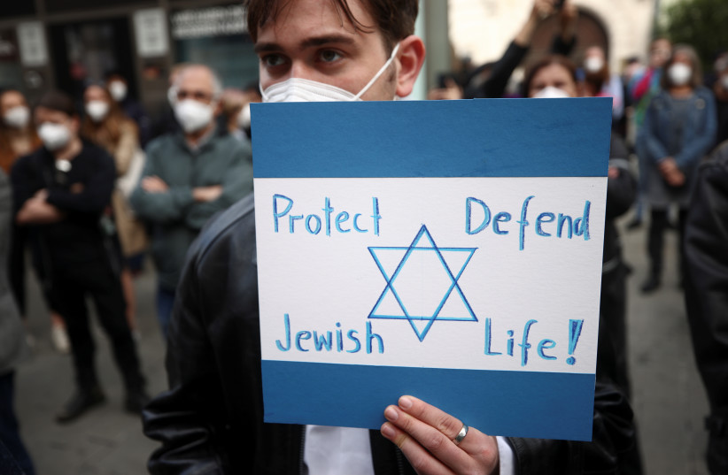   Seorang demonstran pro-Israel memegang plakat selama protes menyusul kekerasan antara Israel dan Palestina, di Wina, Austria, 15 Mei 2021. (kredit: REUTERS/LISI NIESNER)