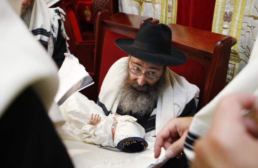  RABBI YEHUDA MATUSOF holds his eight-day-old grandson during a circumcision ceremony in Brussels. The book discusses circumcision and a wide variety of other practices and attitudes toward the Jewish body. (photo credit: Francois Lenoir/Reuters)
