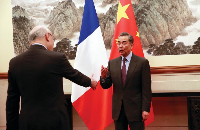  THEN-DIPLOMATIC advisor to the French President, Philippe Etienne, welcomes Chinese Foreign Minister Wang Yi during their meeting in Beijing, in 2019. (photo credit: How Hwee Young/Reuters)
