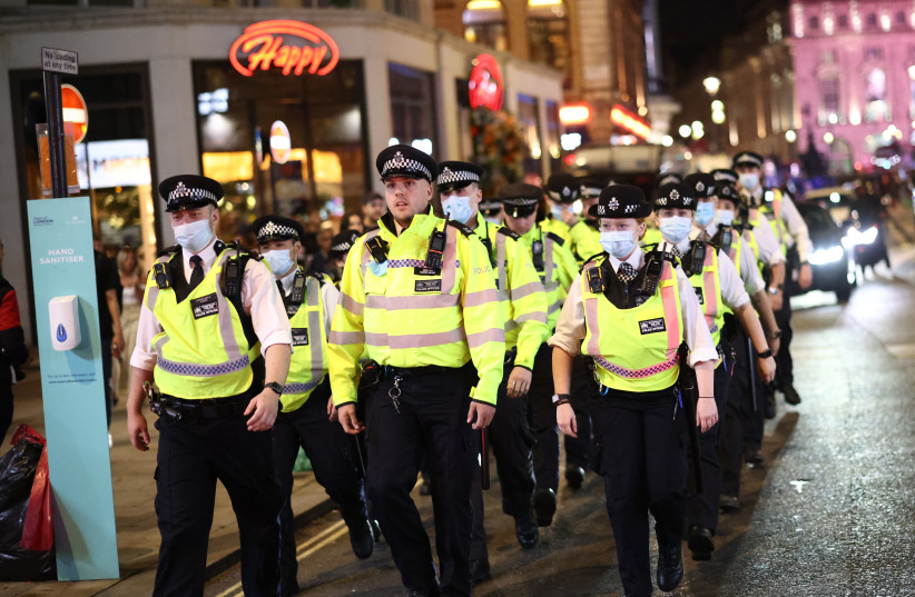  Soccer Football - Euro 2020 - Fans gather in London ahead of Ukraine v England - London, Britain - July 3, 2021 Police officers are seen as England fans celebrate after the match. (photo credit: REUTERS/HENRY NICHOLLS)