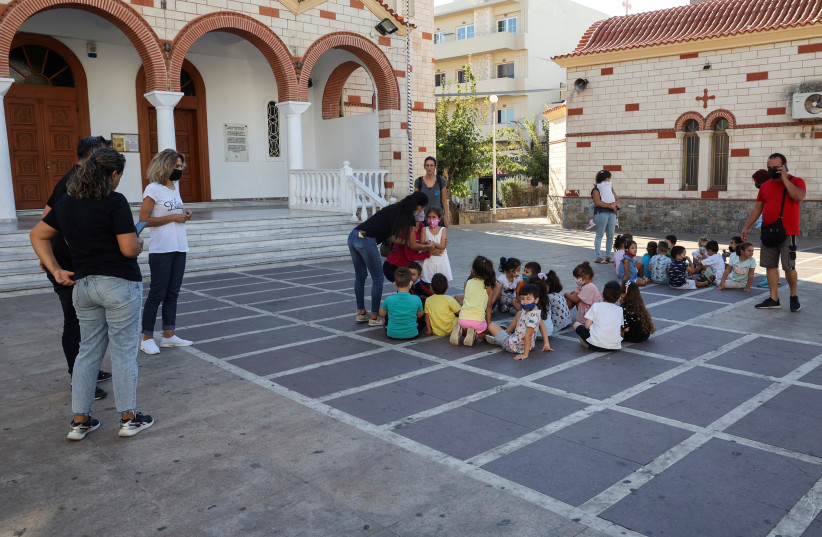  Students and their teachers are seen at a square following an earthquake in Heraklion, on the island of Crete, Greece, September 27, 2021. (photo credit: REUTERS/STEFANOS RAPANIS)