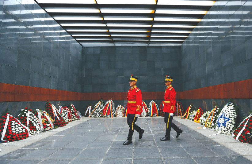   ROMANIAN SOLDIERS lay wreaths at a Holocaust memorial in Bucharest in 2014.  (photo credit: REUTERS/BOGDAN CRISTEL)