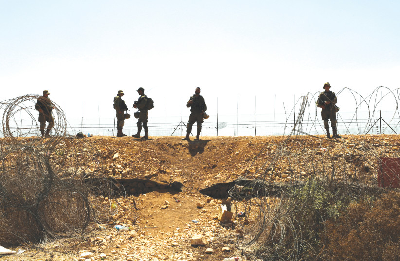  IDF soldiers guard a fence near the West Bank.  (photo credit: AMMAR AWAD/REUTERS)