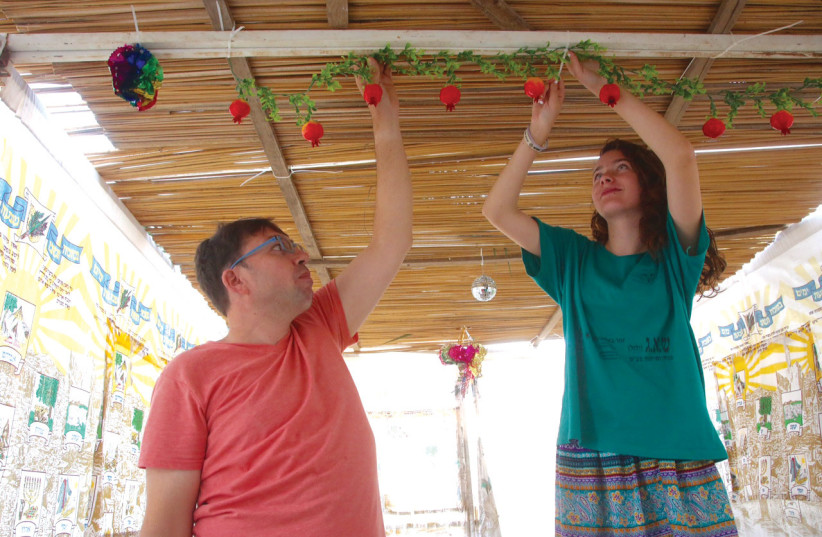  Orly and Laurent decorate their sukkah in Ma’ale Levona. (photo credit: MARC ISRAEL SELLEM)