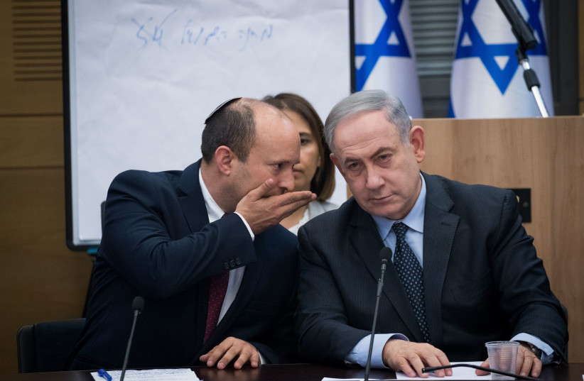 Then prime minister Benjamin Netanyahu speaks with then minister of Defense and leader of the Yamina party Naftali Bennett, March 4, 2020.  (credit: YONATAN SINDEL/FLASH90)