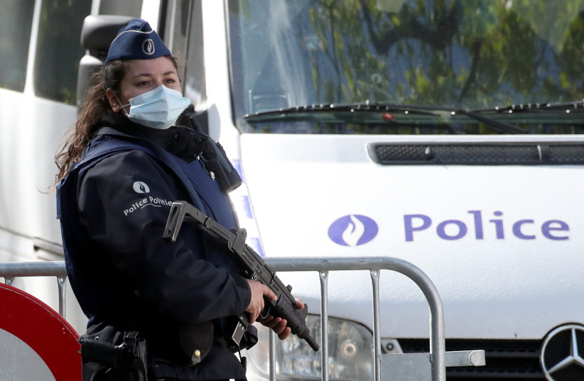  A member of the Belgian police stands guard outside National Park Hoge Kempen, while scouring to capture Belgian Jurgen Conings, a soldier who disappeared after threatening a virologist supportive of coronavirus disease (COVID-19) vaccines and coronavirus restrictions, in Maasmechelen, Belgium (photo credit: YVES HERMAN/REUTERS)