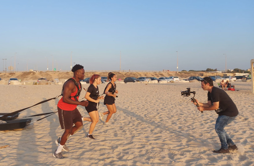  ABDUL RUNS with Emmanuelle Avrahami (center) and Marian Awad, Israeli National Women’s Soccer Team players – pulling sand sleds they will fill with garbage as part of their workout, as Ran Shneck films them for an Environmental Fitness video (photo credit: Courtesy)