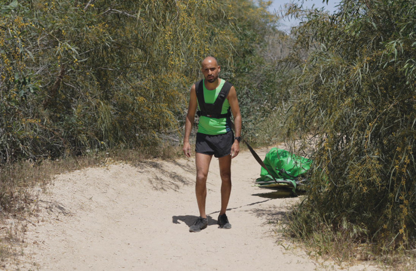  DOING his ‘badass workout’: Daniel Campos Putterman, Environmental Fitness co-founder, hauls a bag of trash in the Nitzanim Sand Dune Nature Reserve.  (credit: RAN SHNECK)