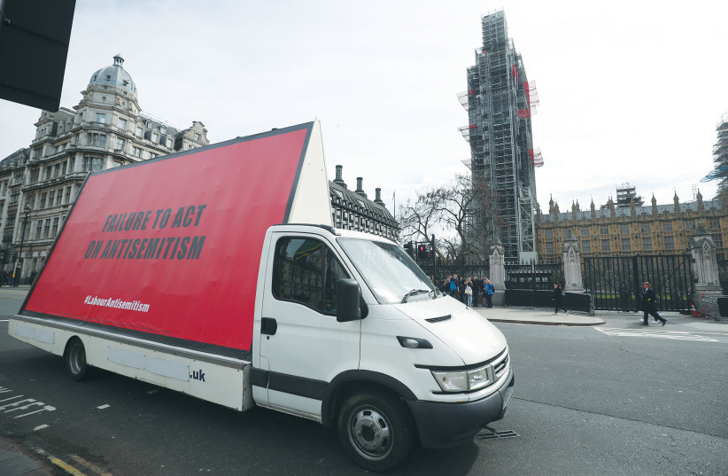  A VAN WITH a slogan aimed at Britain’s Labour Party is driven around London’s Parliament Square ahead of a debate on antisemitism in Parliament, in April 2018. (photo credit: REUTERS/HANNAH MCKAY)