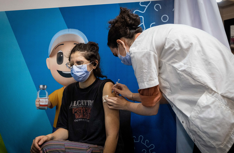  A woman receives a dose of the COVID-19 vaccine at a temporary Clalit health care center in Jerusalem, September 30, 2021.  (credit: YONATAN SINDEL/FLASH90)