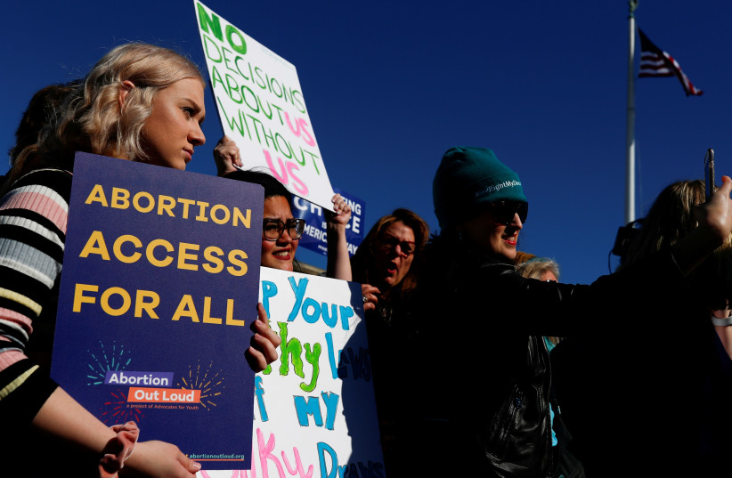  Pro-choice demonstrators hold up signs during a group chant outside of the U.S. Supreme Court as justices hear a major abortion case on the legality of a Republican-backed Louisiana law that imposes restrictions on abortion doctors, on Capitol Hill in Washington, US, March 4, 2020. (credit: REUTERS/TOM BRENNER/FILE PHOTO)
