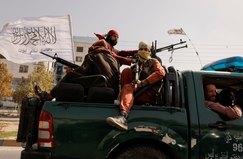 Members of Taliban forces ride on a pick-up truck mounted with a weapon in Kabul, Afghanistan, October 3, 2021. (photo credit: REUTERS/JORGE SILVA)