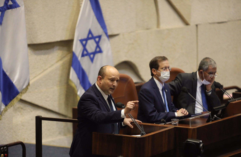  Le Premier ministre Naftali Bennett prend la parole lors du plénum de la Knesset en présence du président Isaac Herzog et du président de la Knesset Mickey Levy le 4 octobre 2021. (Crédit : MARC ISRAEL SELLEM)