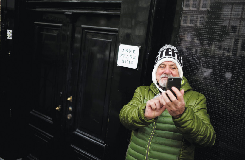  AN ITALIAN tourist takes a selfie in  front of the Anne Frank House in  Amsterdam, 2017 (credit: REUTERS/CRIS TOALA OLIVARES)