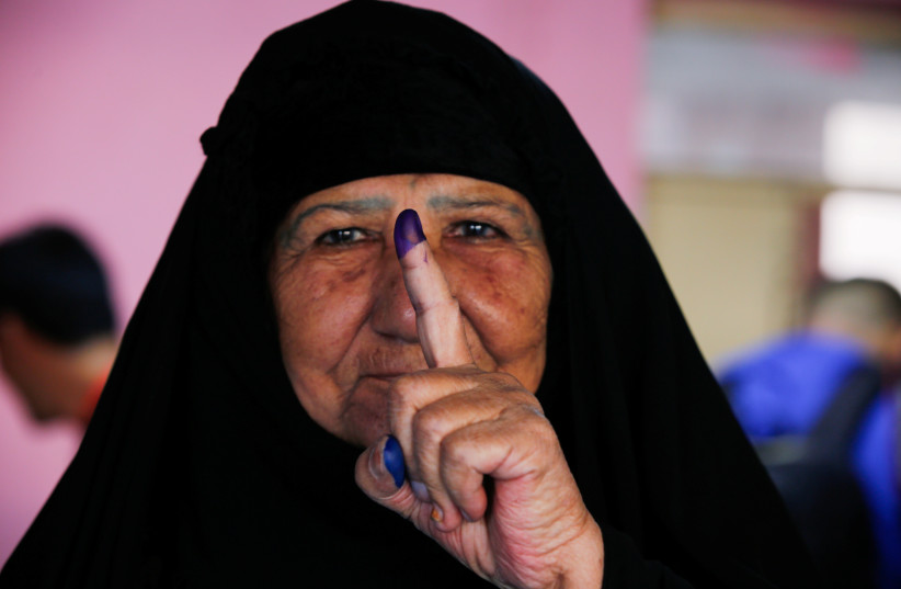  An Iraqi woman shows her ink-stained finger after casting her vote at a polling station during the parliamentary election in the Sadr city district of Baghdad, Iraq October 10, 2021.  (photo credit: REUTERS/WISSAM AL-OKAILI)