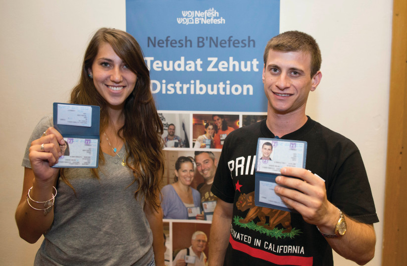  NEW IMMIGRANTS receive their ID, after a ceremony welcoming them to Israel. (photo credit: YONATAN SINDEL/FLASH90)