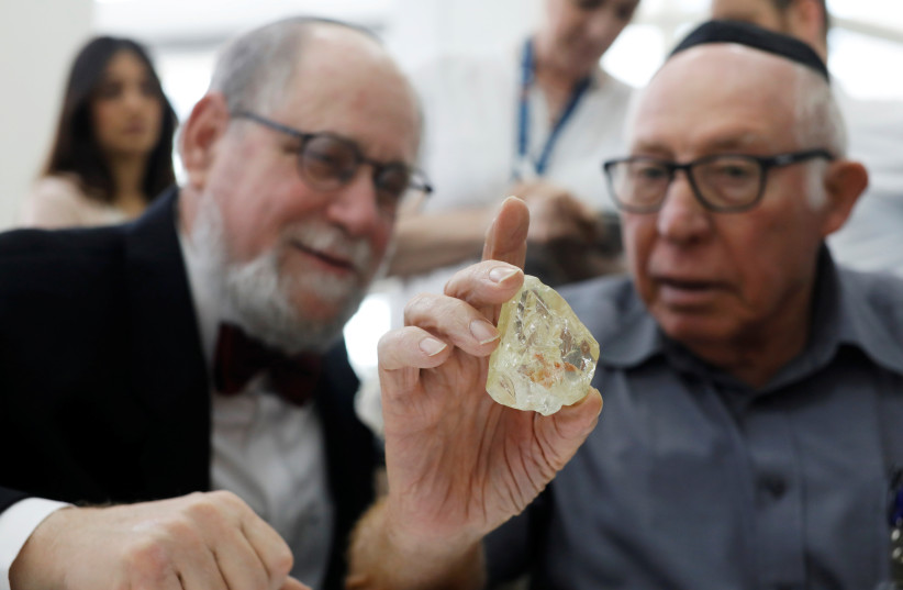  A trader inspects a 709-carat diamond, found in Sierra Leone and known as the ‘Peace Diamond,’ as Martin Rapaport, chairman of the Rapaport Group, looks on, at Israel’s Diamond Exchange in Ramat Gan on October 19, 2017. (credit: NIR ELIAS/REUTERS)