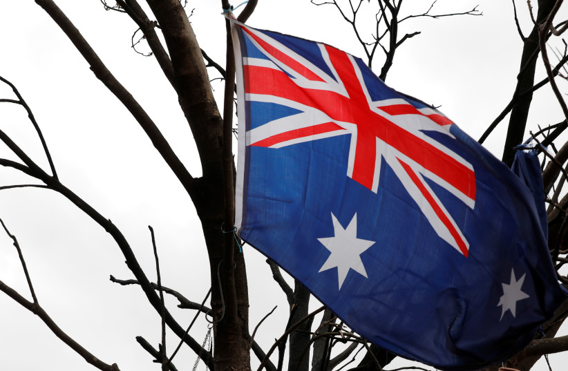  An Australian flag is seen hung in a tree burnt by bushfire on the property of farmer Jeff McCole in Buchan, Victoria, Australia (photo credit: REUTERS/ANDREW KELLY)