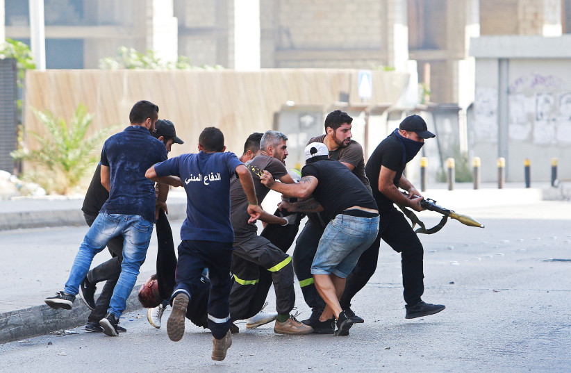  People evacuate a casualty after gunfire erupted in Beirut, Lebanon October 14, 2021. (photo credit: AZIZ TAHER/REUTERS)
