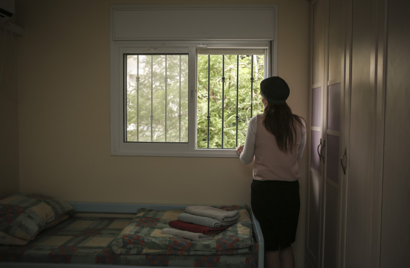  An Orthodox Jewish woman looks out the window of her room in the abused women's shelter in Beit Shemesh, July 15, 2014 (credit: HADAS PARUSH/FLASH90)