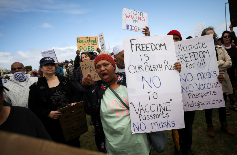  Anti-vaccine protestors hold placards during a march against coronavirus disease (COVID-19) vaccinations on the Sea Point promenade in Cape Town, South Africa (credit: REUTERS/MIKE HUTCHINGS)