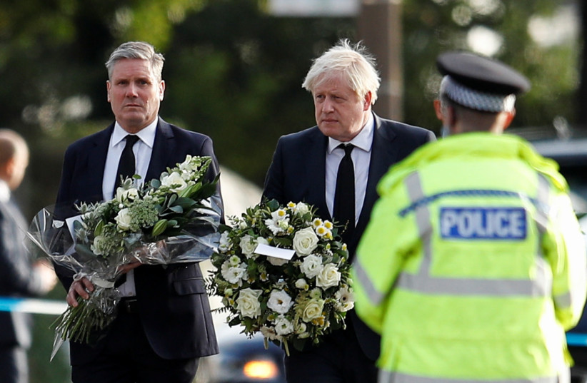  Britain's Labour Party leader Keir Starmer and Prime Minister Boris Johnson hold flowers as they arrive at the scene where British MP David Amess was stabbed to death during a meeting with constituents at the Belfairs Methodist Church, in Leigh-on-Sea, Britain, October 16, 2021.  (credit: REUTERS/PETER NICHOLLS)