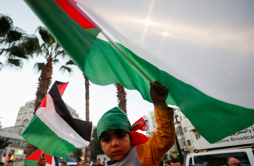  A child waves a flag as demonstrators take part in a protest in solidarity with Palestinian prisoners in Israeli jails, in Ramallah in the West Bank September 8, 2021. (photo credit: MOHAMAD TOROKMAN/REUTERS)
