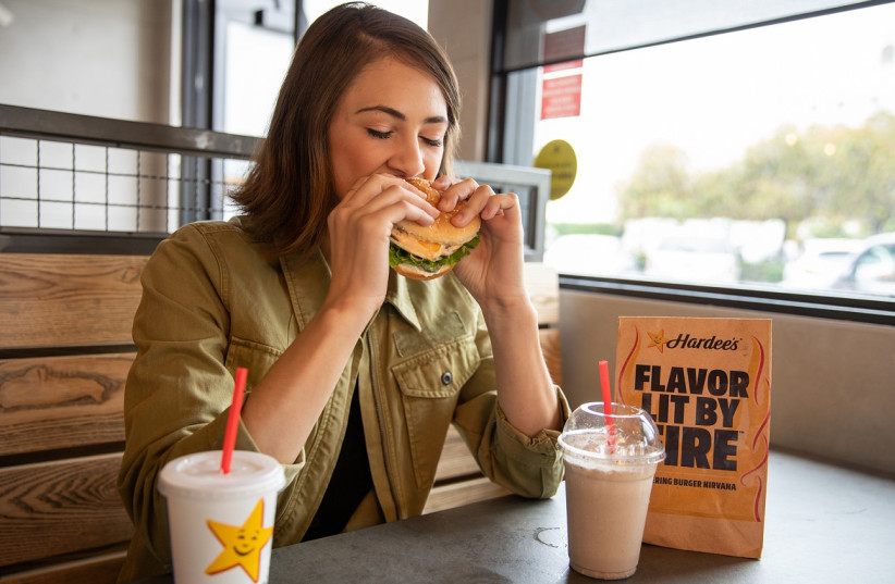   Hardee's customer enjoys a burger. (photo credit: Courtesy)